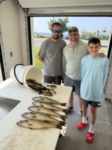 Family with a catch of White Lake walleyes, bluegills, and perch after a guided fishing charter near Whitehall, Michigan with Dave's Fishing Charters.