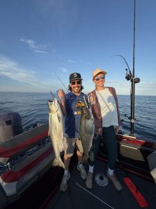appy anglers holding two king salmon during a Lake Michigan fishing charter near Whitehall, Michigan aboard Dave's Fishing Charters.